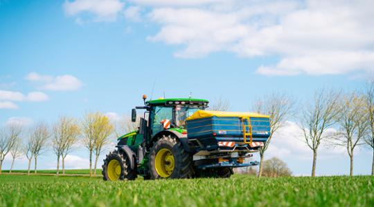 Spreader on a green field 